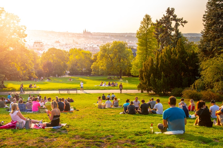 sunset in Rieger Gardens, Riegrovy sady, in Prague. Many people sitting in the grass and enjoying sunny summer evening and lookout of Prague historical city centre. Czech Republic